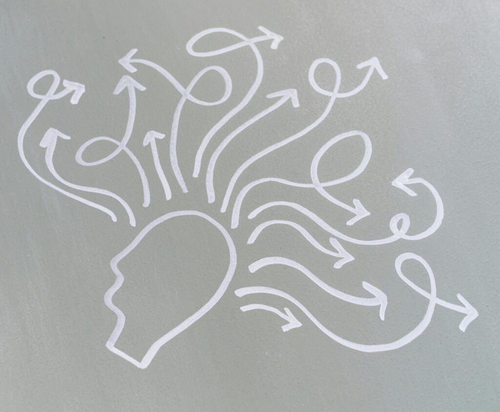 Chalk drawing of a head with swirling arrows represents mental activity and thought process.